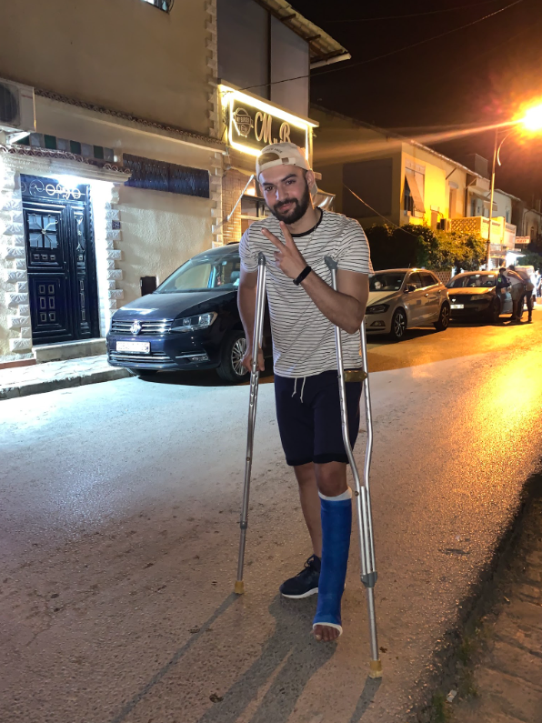 Aimene at 21, on crutches with a cast after the ankle injury that started everything